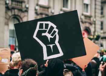 a person holding a sign with a fist drawn on it