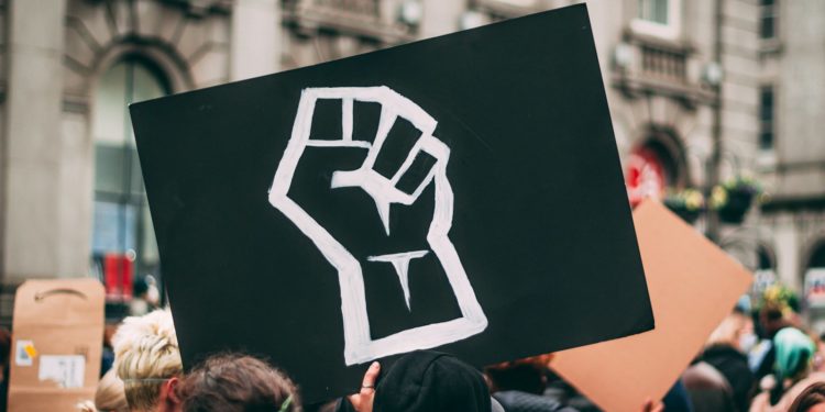 a person holding a sign with a fist drawn on it