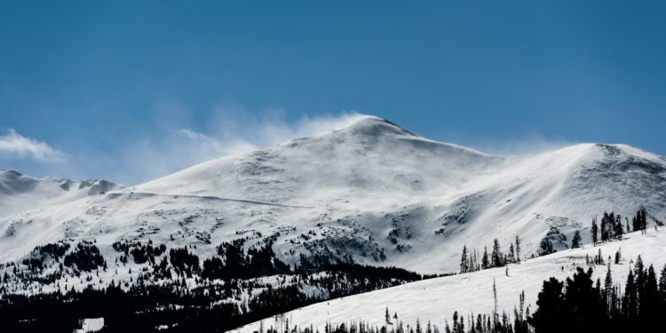 snow capped mountain under blue skies