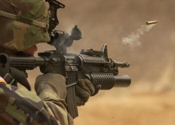 Close-up of a soldier in camo firing a rifle in action during training.