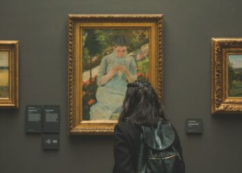 a woman looking at a painting in a museum