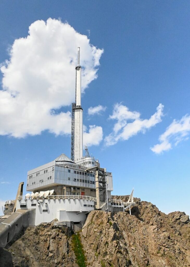 A tall building sitting on top of a rocky hill